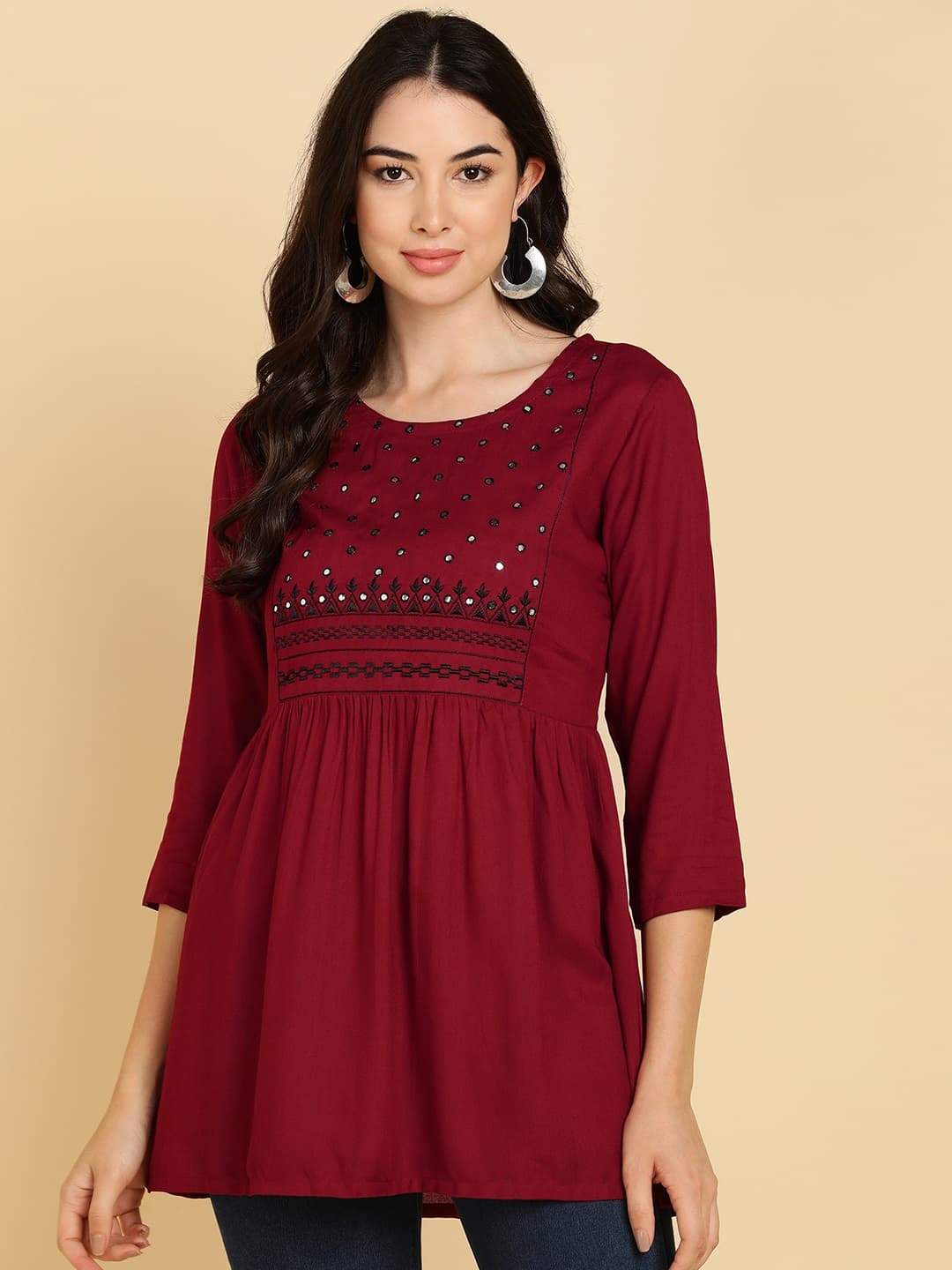 Woman wearing a maroon short kurti tunic top by Nishtha Chadda