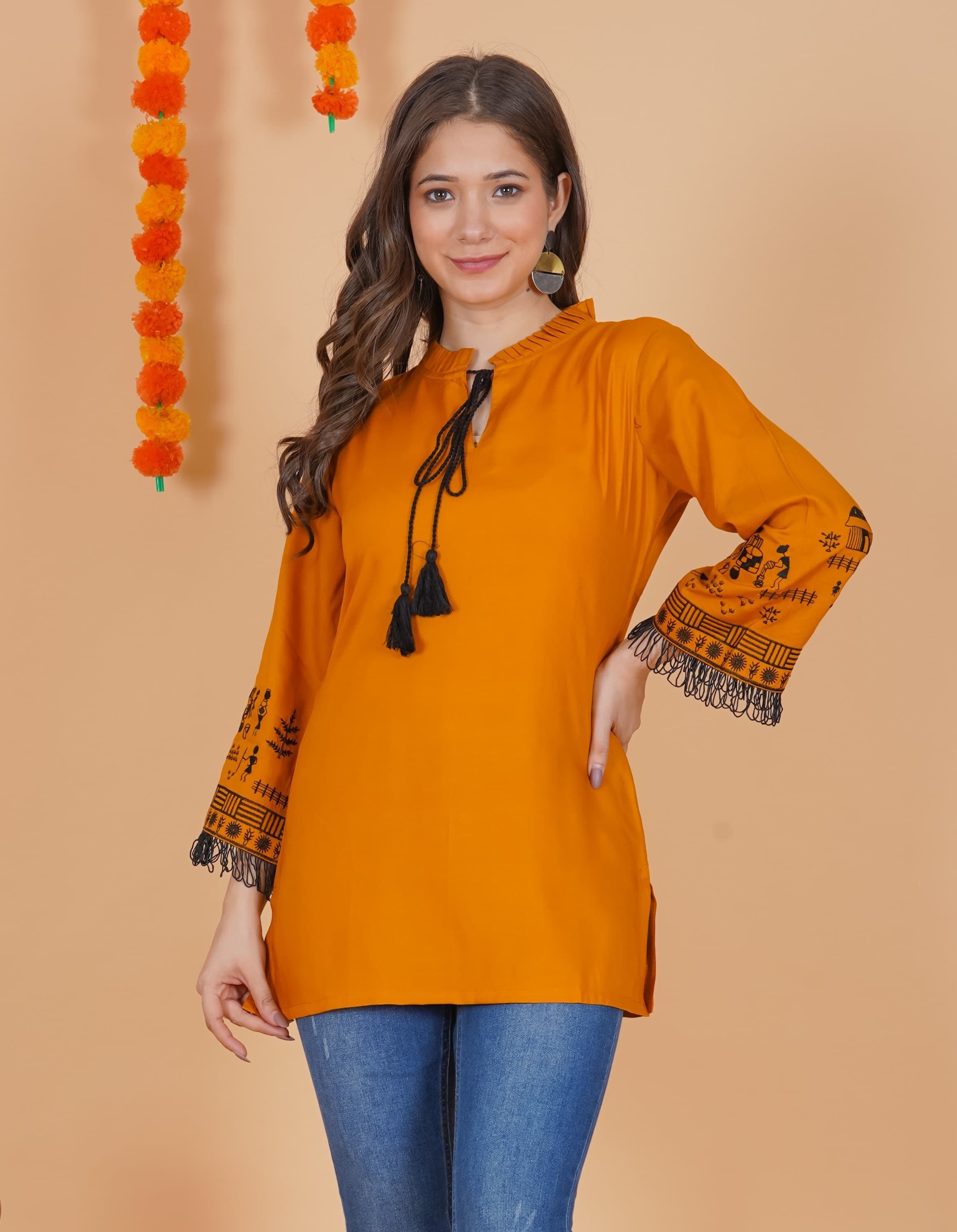Woman wearing a orange tunic top for women by Nishtha Chadda
