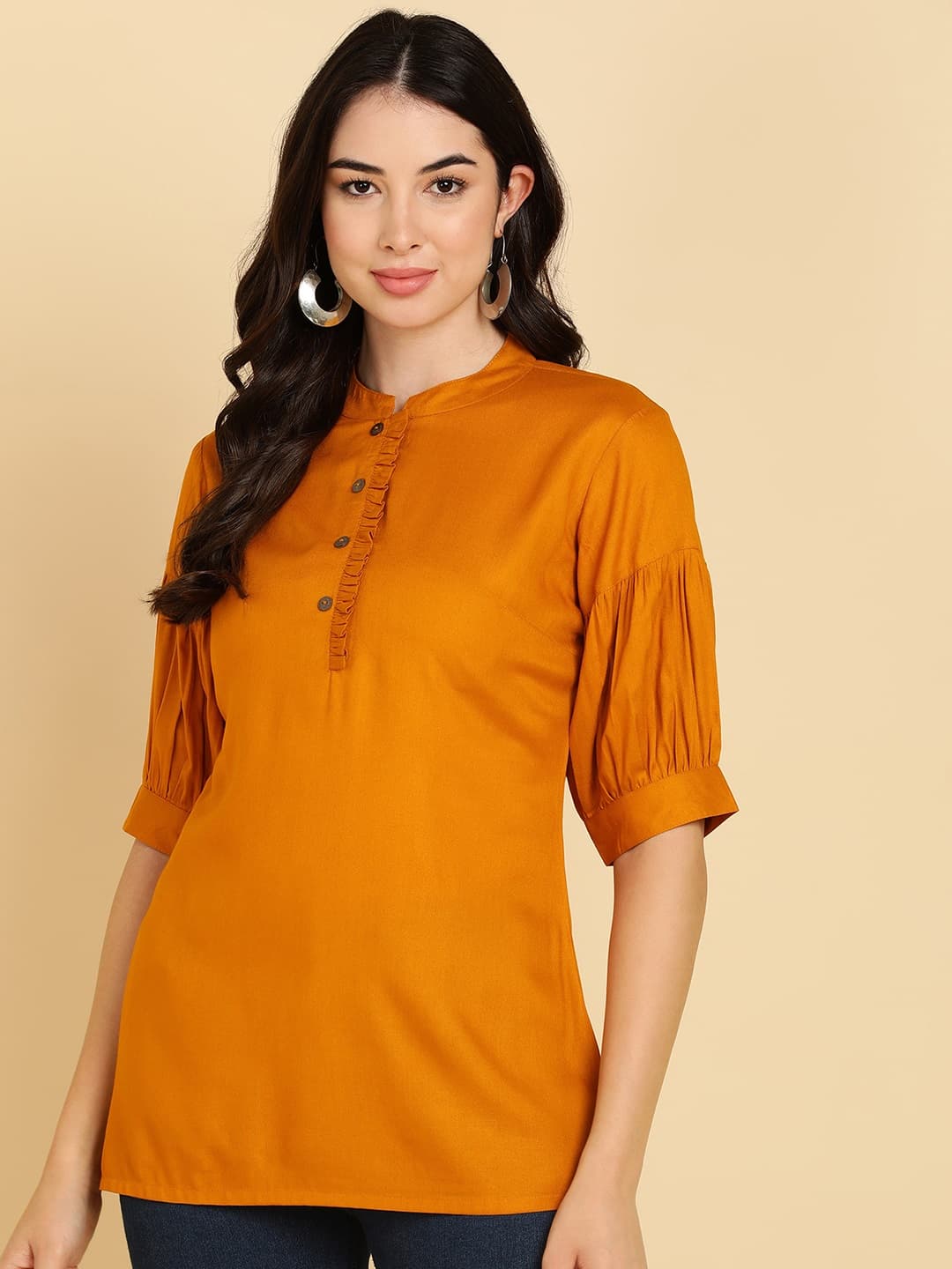 Woman wearing a orange tunic top for women by Nishtha Chadda
