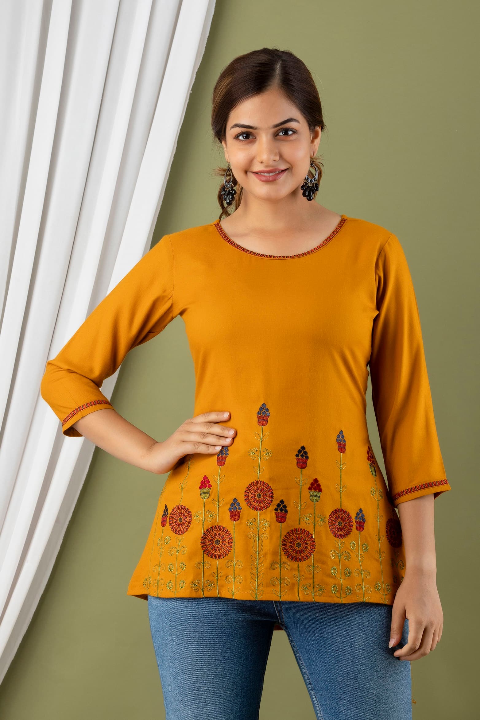 Woman wearing a orange tunic top for women by Nishtha Chadda