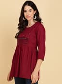 Woman wearing a maroon short kurti tunic top by Nishtha Chadda