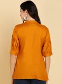 Woman wearing a maroon short kurti tunic top by Nishtha Chadda