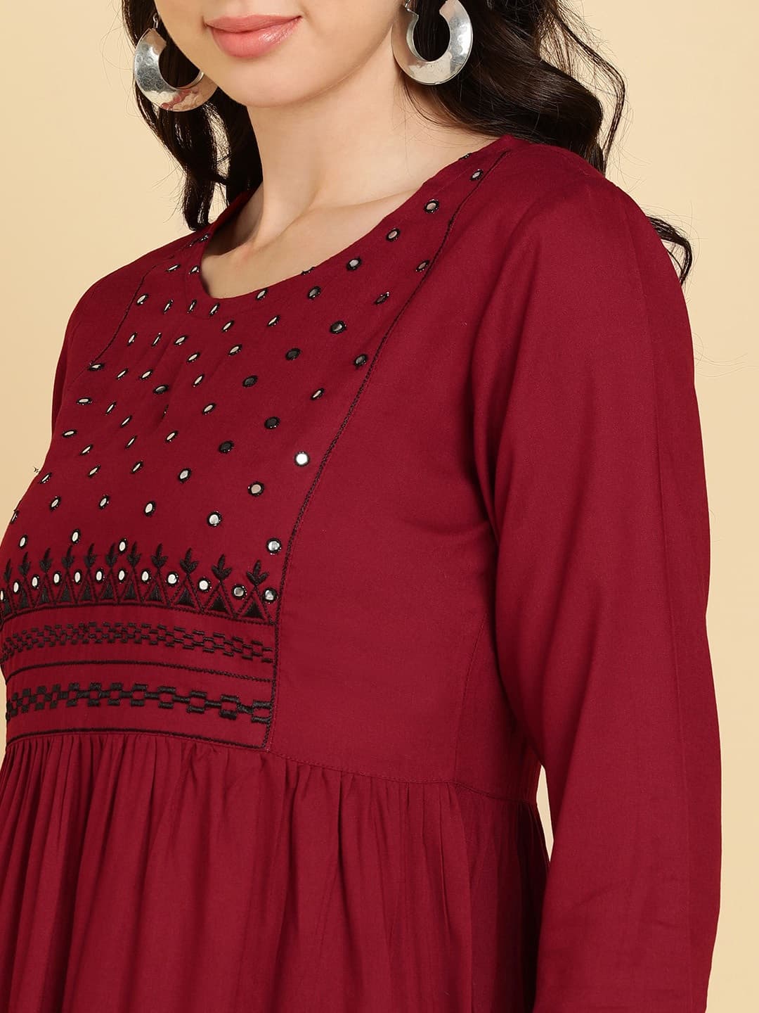 Woman wearing a maroon party wear ethnic kurta style by Nishtha Chadda