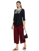 Woman wearing a maroon party wear ethnic kurta style by Nishtha Chadda