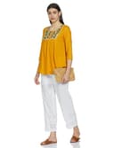 Woman wearing a mustard party wear ethnic kurta style by Nishtha Chadda