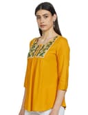 Woman wearing a mustard party wear ethnic kurta style by Nishtha Chadda