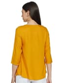 Woman wearing a mustard party wear ethnic kurta style by Nishtha Chadda