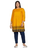 Woman wearing a mustard party wear ethnic kurta style by Nishtha Chadda