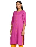 Woman wearing a coral party wear ethnic kurta style by Nishtha Chadda