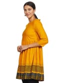 Woman wearing a mustard party wear ethnic kurta style by Nishtha Chadda