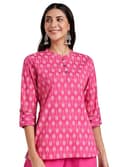 Woman wearing a coral party wear ethnic kurta style by Nishtha Chadda