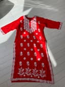 Woman wearing a red embroidered kurti set by Nishtha Chadda