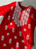Woman wearing a red embroidered kurti set by Nishtha Chadda