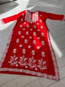 Woman wearing a red embroidered kurti set by Nishtha Chadda