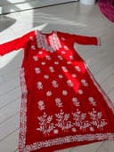 Woman wearing a red embroidered kurti set by Nishtha Chadda