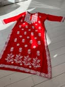 Woman wearing a red embroidered kurti set by Nishtha Chadda