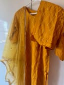 Woman wearing a brown embroidered kurti set by Nishtha Chadda