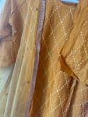 Woman wearing a brown embroidered kurti set by Nishtha Chadda