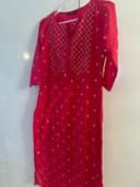 Woman wearing a red embroidered kurti set by Nishtha Chadda