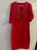 Woman wearing a red embroidered kurti set by Nishtha Chadda