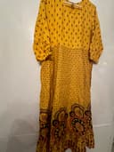 Woman wearing a orange embroidered kurti set by Nishtha Chadda