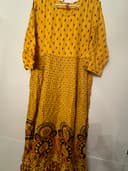 Woman wearing a orange embroidered kurti set by Nishtha Chadda
