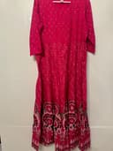 Woman wearing a orange embroidered kurti set by Nishtha Chadda