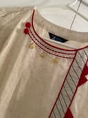Woman wearing a brown embroidered kurti set by Nishtha Chadda