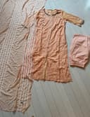 Woman wearing a brown embroidered kurti set by Nishtha Chadda