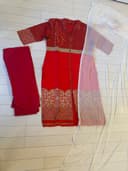 Woman wearing a red embroidered kurti set by Nishtha Chadda