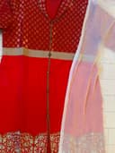 Woman wearing a red embroidered kurti set by Nishtha Chadda