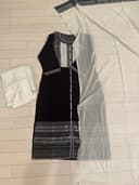 Woman wearing a beige embroidered kurti set by Nishtha Chadda