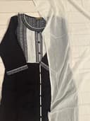 Woman wearing a beige embroidered kurti set by Nishtha Chadda