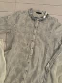 Woman wearing a beige embroidered kurti set by Nishtha Chadda