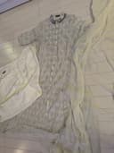 Woman wearing a beige embroidered kurti set by Nishtha Chadda