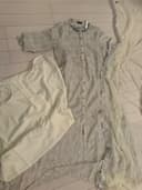 Woman wearing a beige embroidered kurti set by Nishtha Chadda