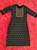 Woman wearing a brown embroidered kurti set by Nishtha Chadda