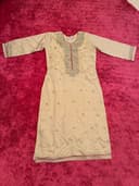 Woman wearing a maroon embroidered kurti set by Nishtha Chadda