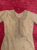 Woman wearing a maroon embroidered kurti set by Nishtha Chadda