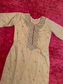 Woman wearing a maroon embroidered kurti set by Nishtha Chadda