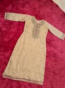 Woman wearing a maroon embroidered kurti set by Nishtha Chadda