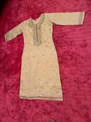 Woman wearing a maroon embroidered kurti set by Nishtha Chadda