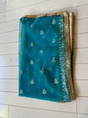 Woman wearing a teal embroidered kurti set by Nishtha Chadda