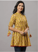 Woman wearing a mustard indian kurti for women by Nishtha Chadda