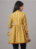Woman wearing a mustard indian kurti for women by Nishtha Chadda
