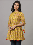 Woman wearing a mustard indian kurti for women by Nishtha Chadda