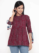 Woman wearing a maroon indian kurti for women by Nishtha Chadda