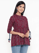 Woman wearing a maroon indian kurti for women by Nishtha Chadda