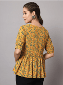 Woman wearing a mustard indian kurti for women by Nishtha Chadda