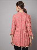 Woman wearing a coral indian kurti for women by Nishtha Chadda